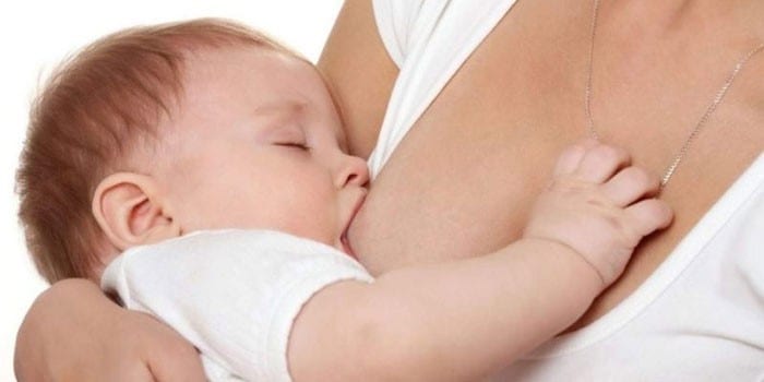 Женщина кормит ребенка грудью