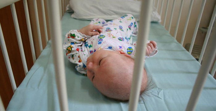 Новорожденный ребенок в кроватке