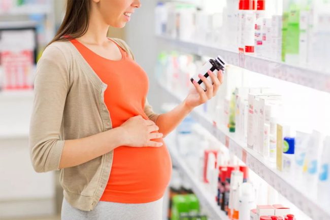 Беременная женщина выбирает витамины