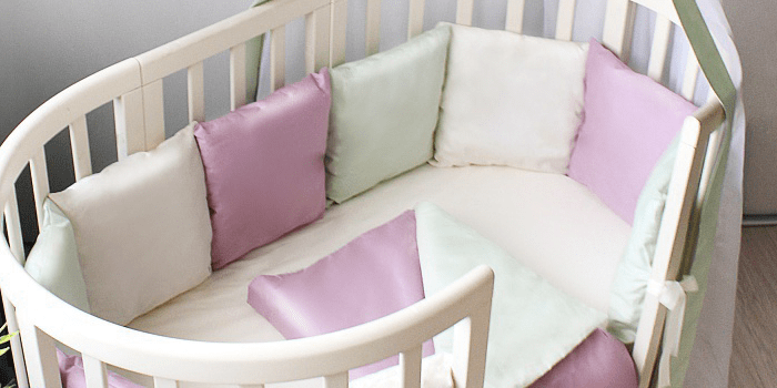 Овальная детская кроватка с разноцветными бортиками Гармония сна