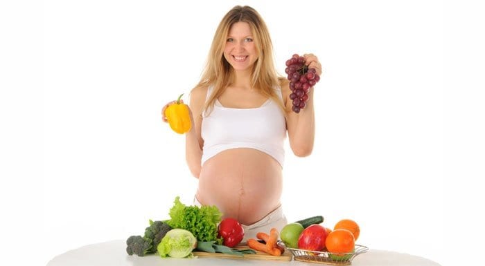 Беременная девушка с овощами и фруктами