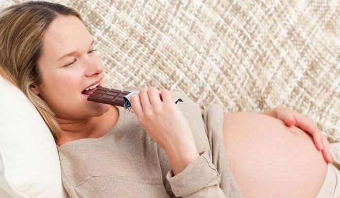 Беременная женщина ест шоколад
