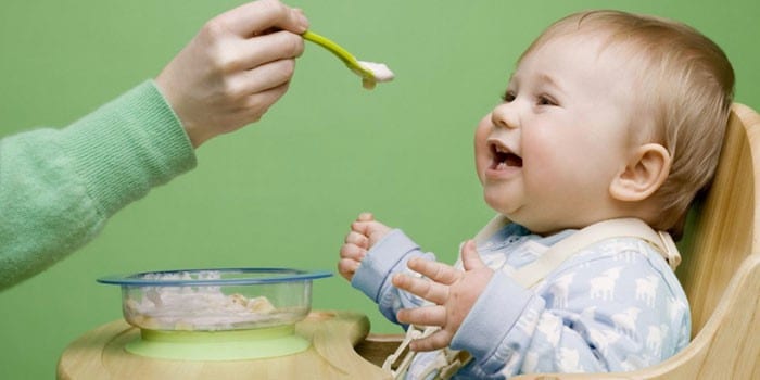 Ребенка кормят из ложечки