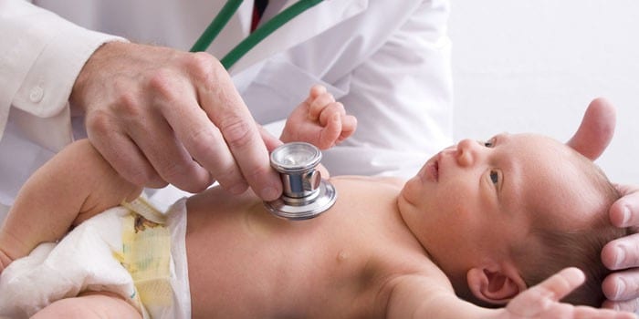 Врач слушает дыхание грудного ребенка стетоскопом 
