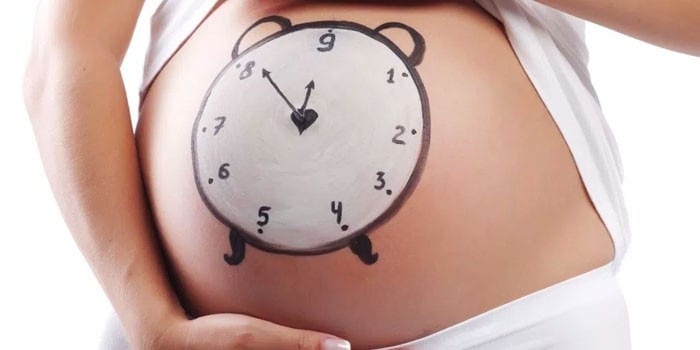 Нарисованные часы на животе беременной женщины