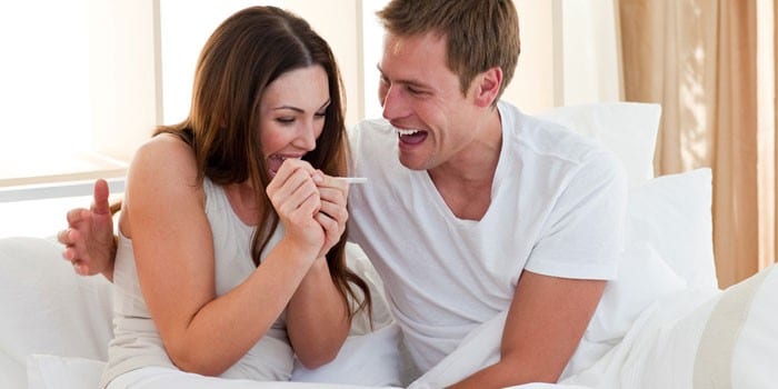 Мужчина и женщина радуются положительному тесту на беременность