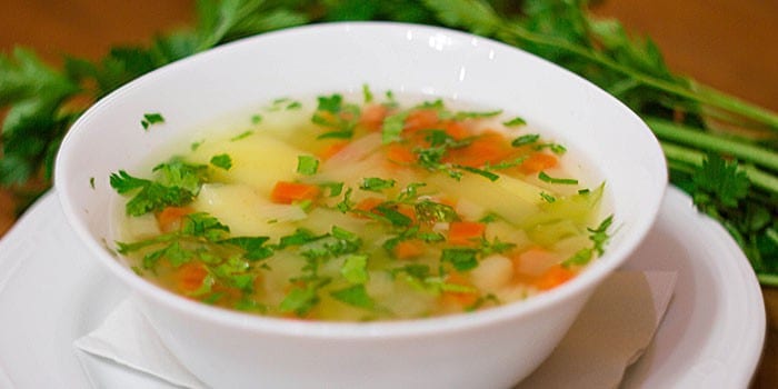 Овощной суп с рисом и курицей в тарелке