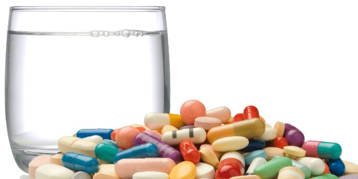 Вода в стакане, таблетки и капсулы