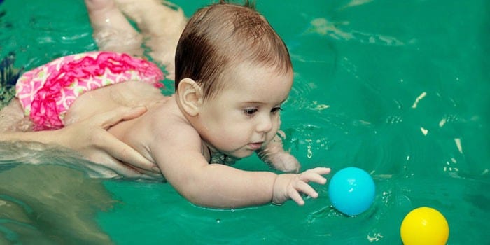 Ребенок плавает в бассейне с мячиками