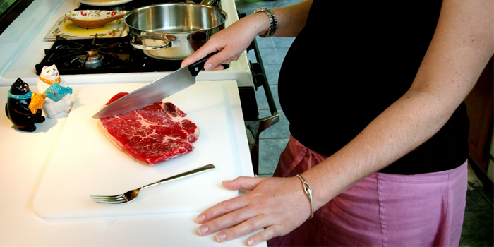 Беременная готовит мясо