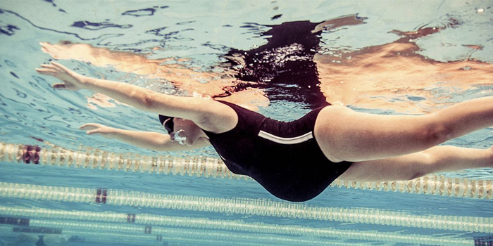 Беременная женщина плавает в бассейне