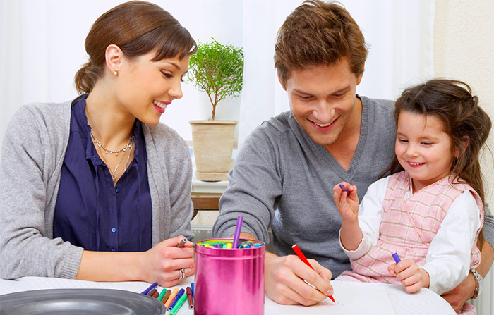 Девочка рисует вместе с родителями