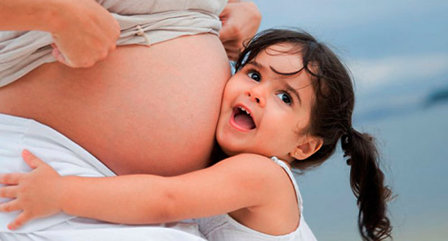 Беременная женщина с дочкой