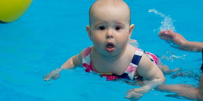 Девочка плавает в бассейне